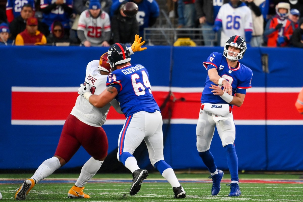Dec 4, 2022; East Rutherford, New Jersey, USA; New York Giants quarterback Daniel Jones (8) passes the ball as guard Mark Glowinski (64) blocks Washington Commanders defensive tackle Daron Payne (94) during overtime at MetLife Stadium.
